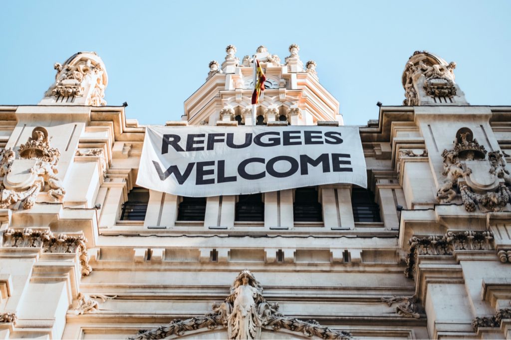 Building with 'Refugees Welcome' banner hanging from it. First Racist Party Past the Post - Priti Patel, Asylum seekers and Rwanda
